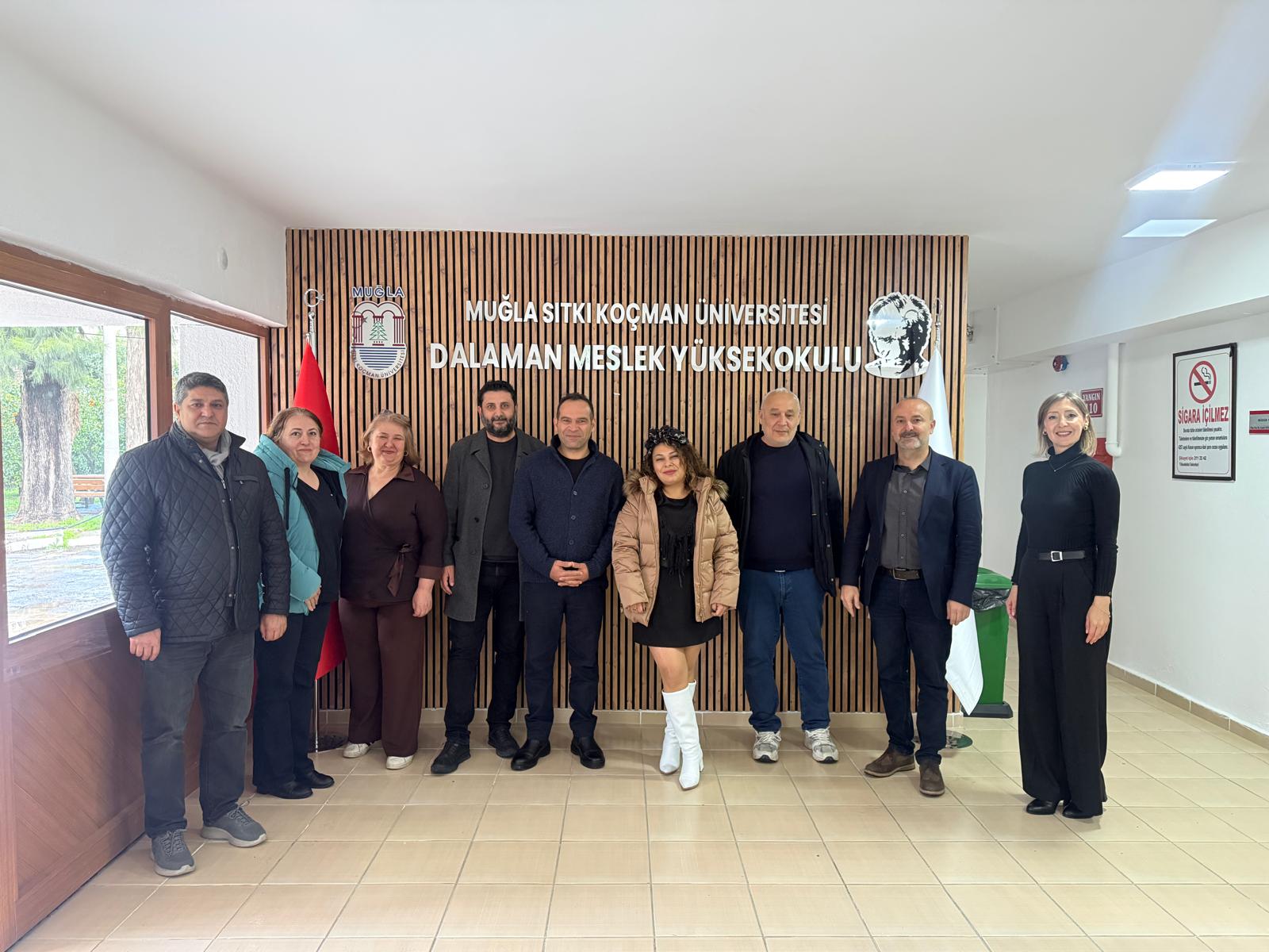 Kadın ve erkeklerden oluşan yaklaşık 10 kişi ayakta fotoğraf çektiriyor. 